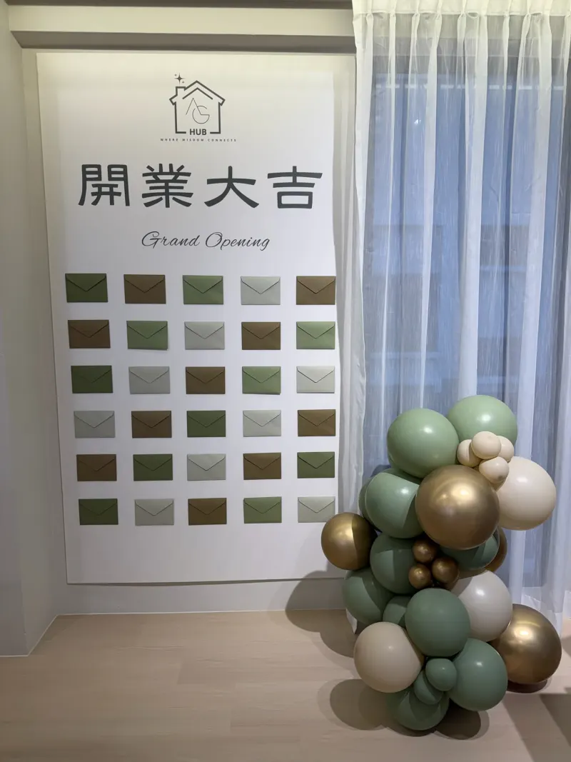 Guests at a balloon arch and greeting wall at the AG Hub opening